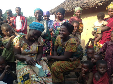Men, women and children from Congo. The two women at the front have big smiles.