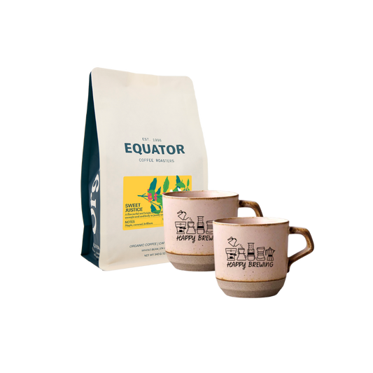 A set of two rustic pink ceramic coffee mugs with a fun brewing design, alongside a bag of Equator coffee.