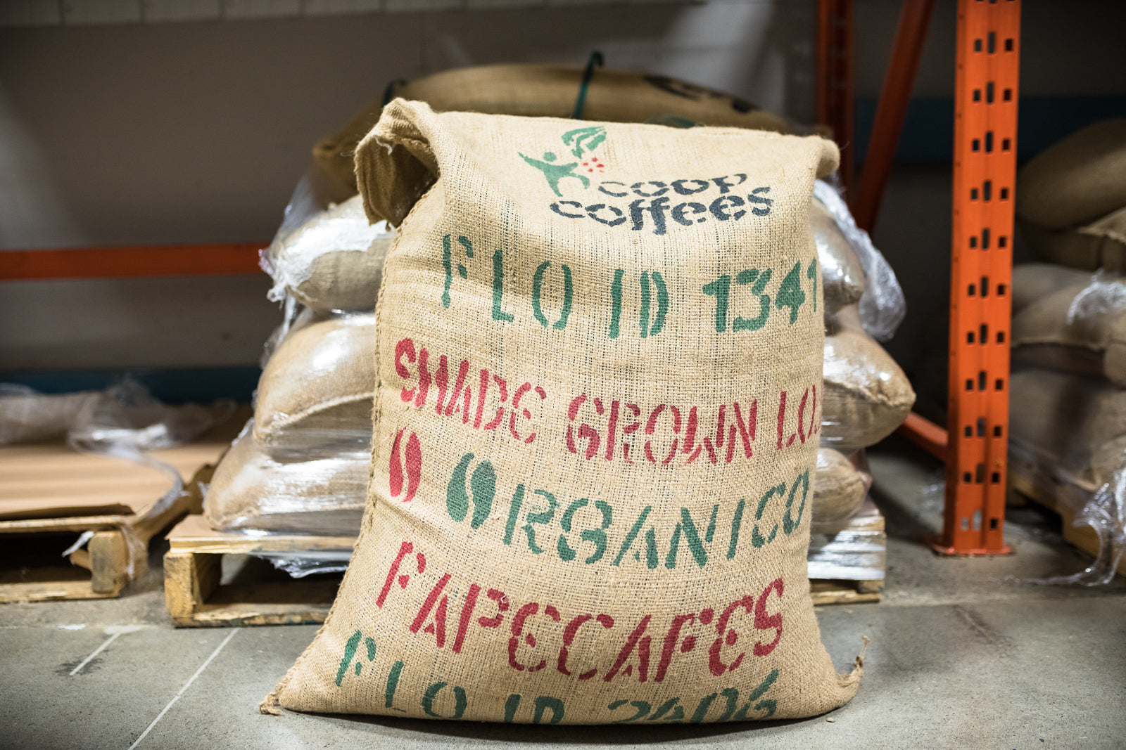 A burlap bag filled with green coffee beans from Coop Coffees.