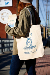 A person with a tote bag with the Probat roaster line drawing on it.